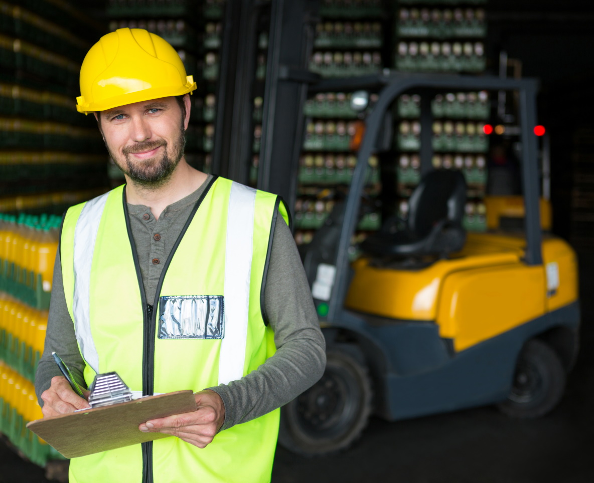 Portrait of smiling male worker writing on clipboard in warehouse